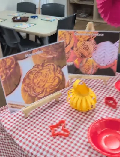Mooncake pictures, a paper lantern and play dough cutters on a gingham table for Mid-Autumn Festival at Eastwood Blessings